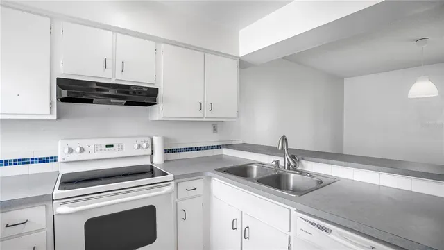 a kitchen with cabinets a sink and white appliances