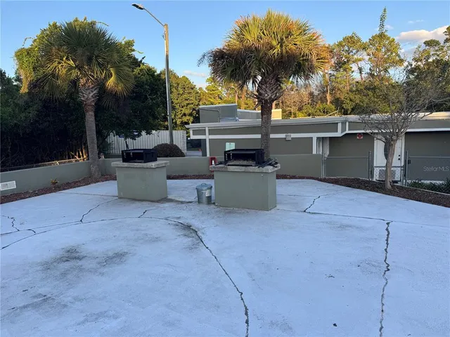 a view of a patio with table and chairs potted plants and palm tree