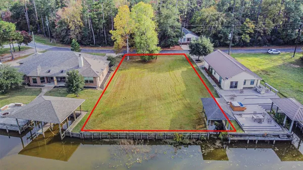 an aerial view of a house with swimming pool and large trees