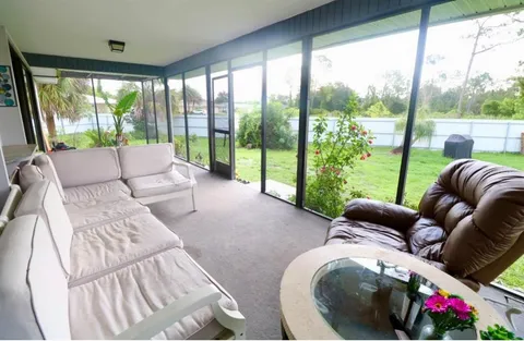 a living room with furniture and a floor to ceiling window