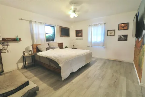 a bedroom with a bed wooden floor and window