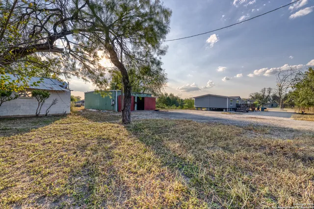 a view of a house with backyard and trees