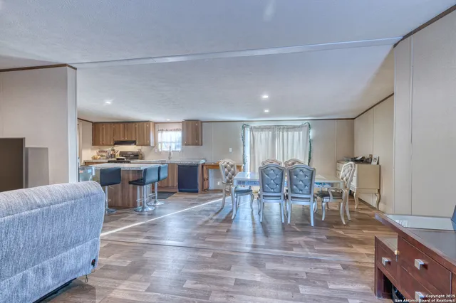 a kitchen with granite countertop kitchen island wooden cabinets a refrigerator stove top oven and sink