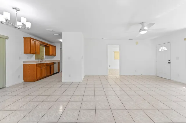 a view of kitchen with granite countertop cabinets and refrigerator