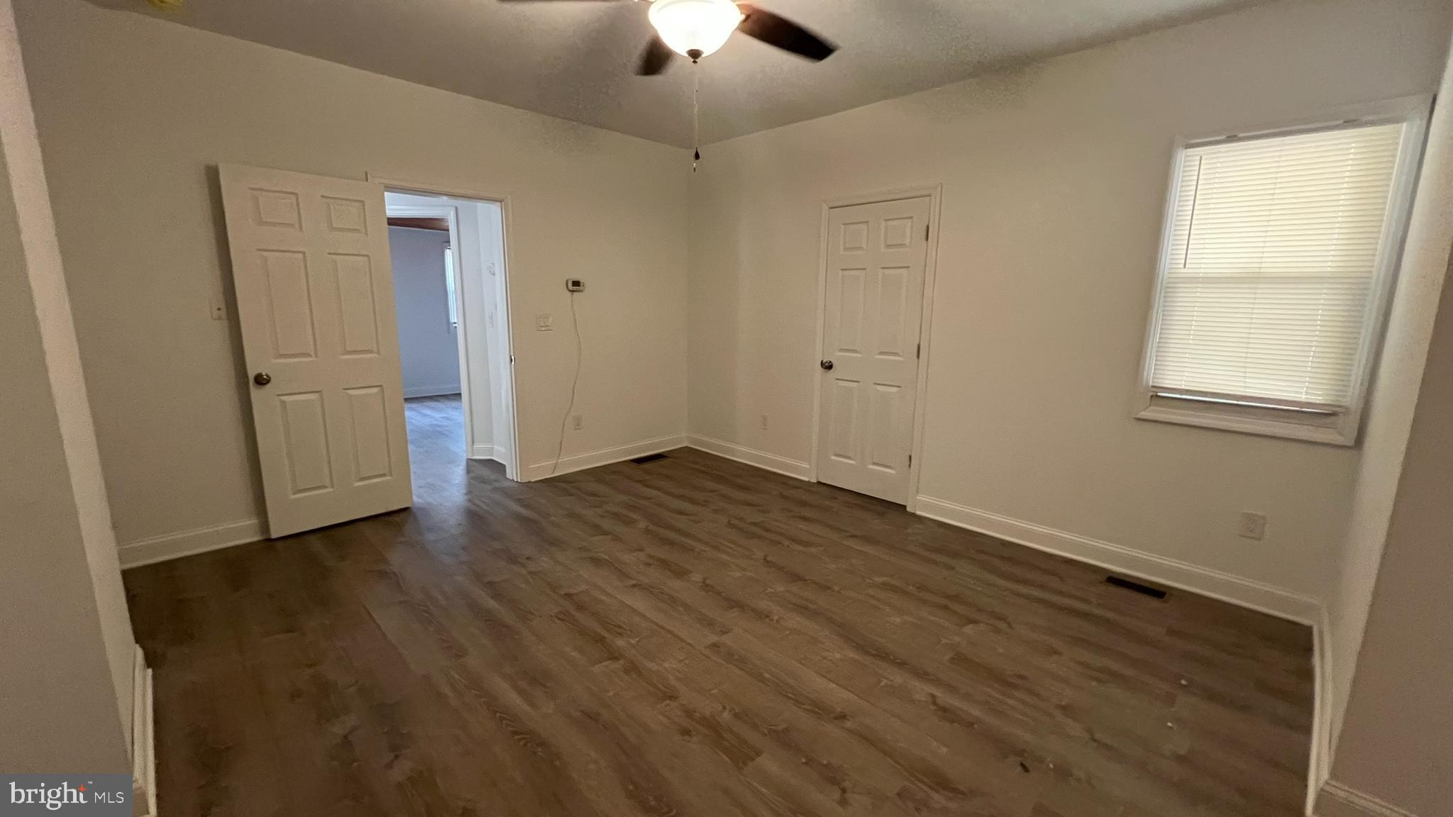 65 Egg Harbor Road, Unit A Berlin, NJ 08009 - Photo 13 of 15 an empty room with wooden floor chandelier fan and windows