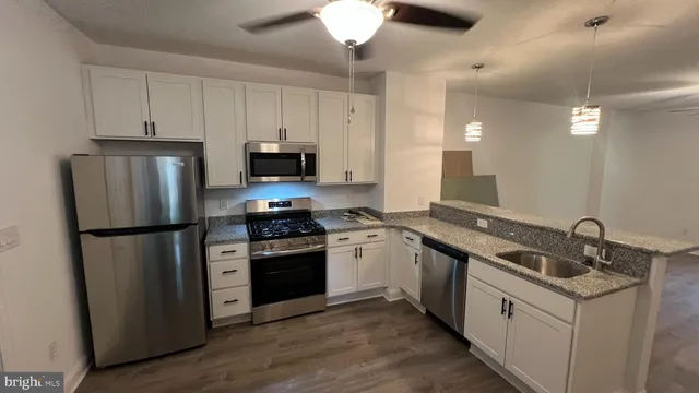 a kitchen with a sink a refrigerator a stove and cabinets