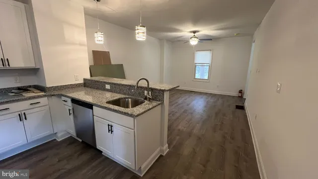 a kitchen with a sink cabinets and wooden floor