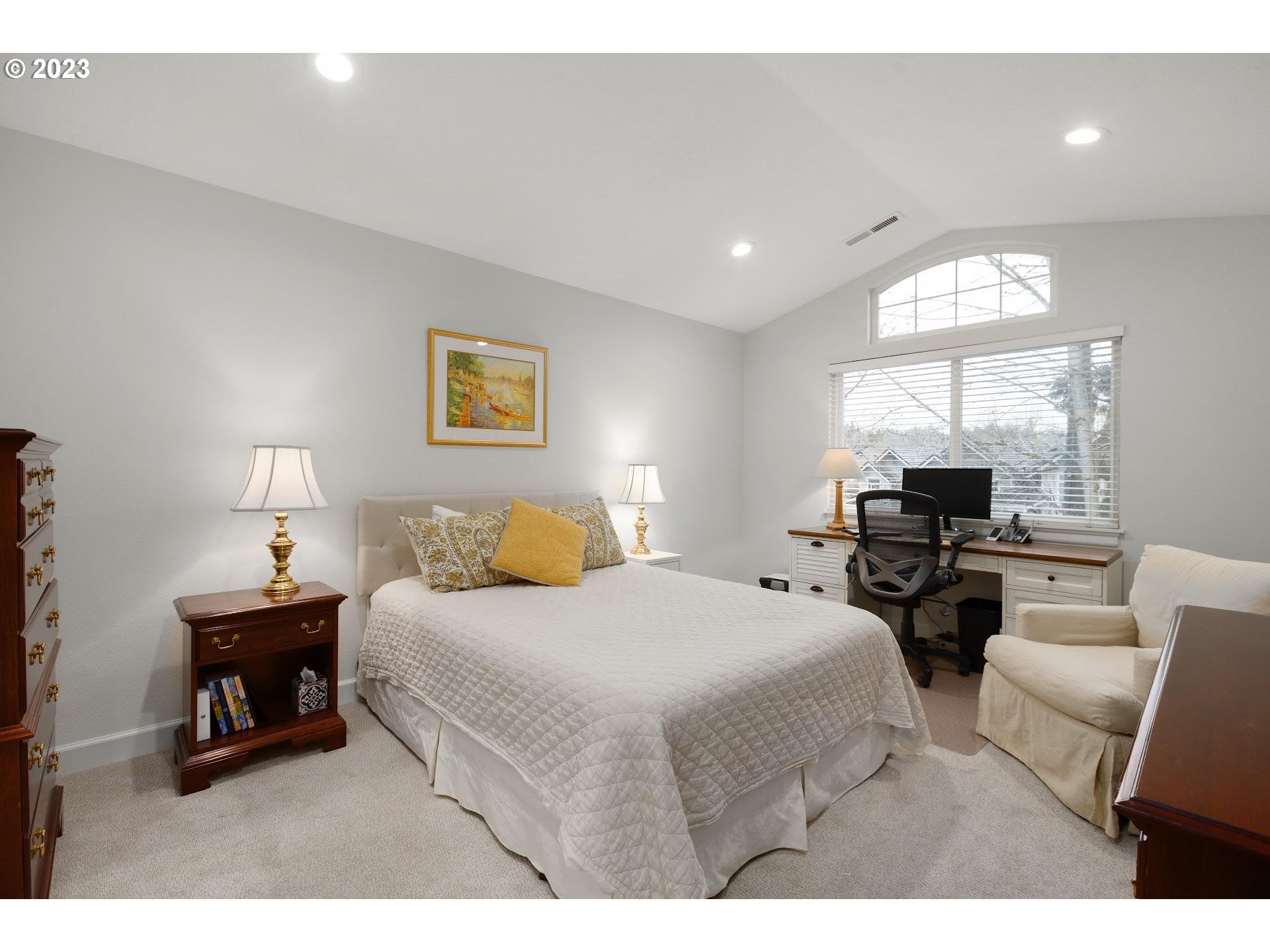 9729 Northwest Silver Ridge Loop Portland, OR 97229 - Photo 16 of 32 a bedroom with a bed a couch and a large mirror