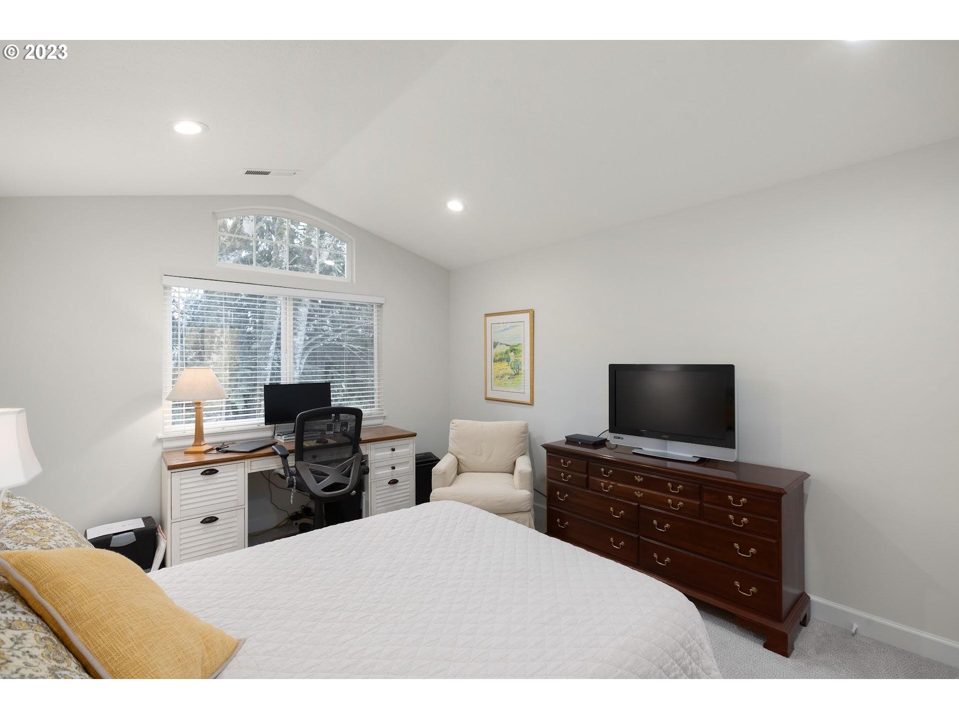 9729 Northwest Silver Ridge Loop Portland, OR 97229 - Photo 17 of 32 a bedroom with a bed and a flat screen tv