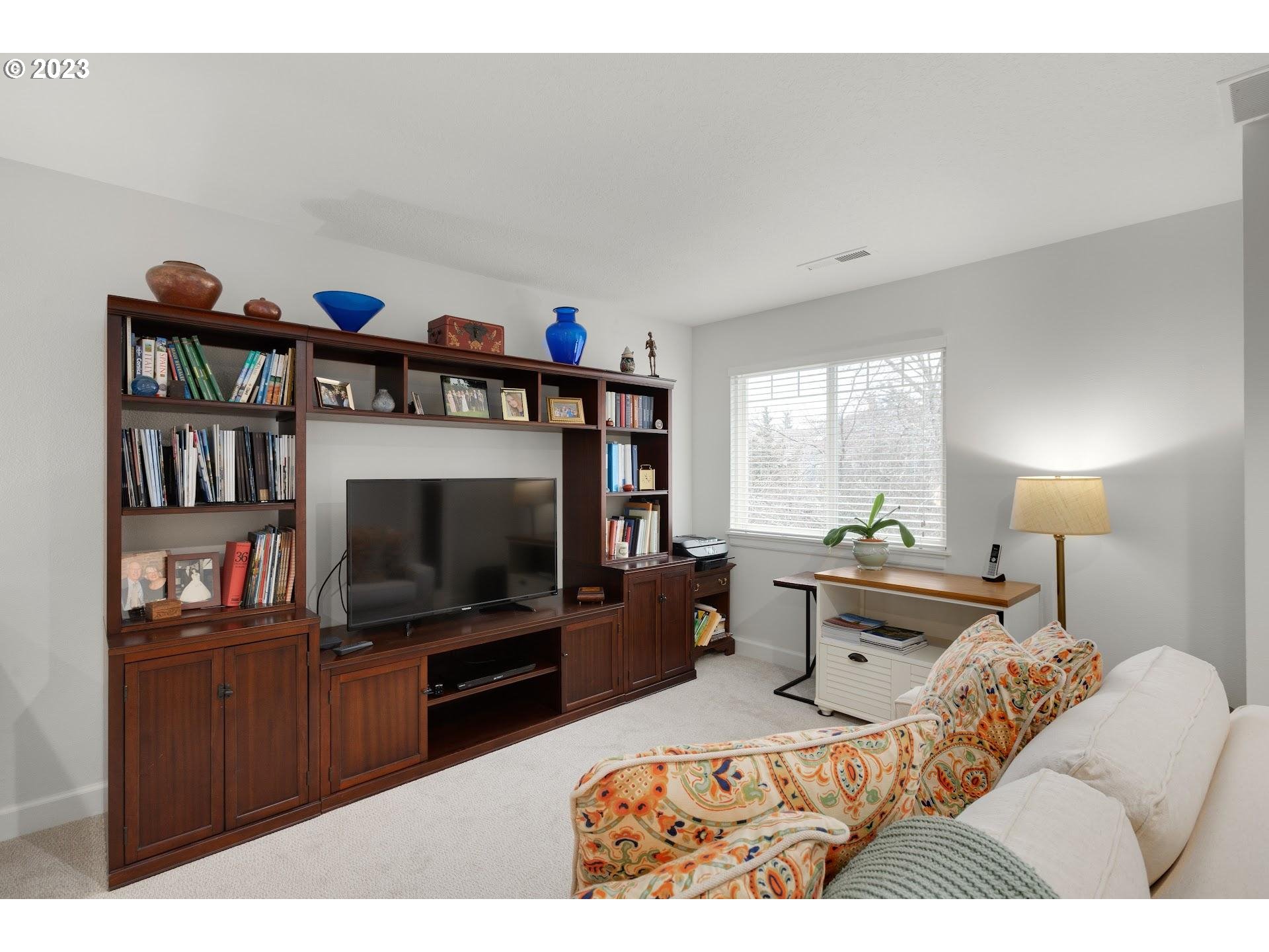 9729 Northwest Silver Ridge Loop Portland, OR 97229 - Photo 21 of 32 a living room with furniture and a flat screen tv