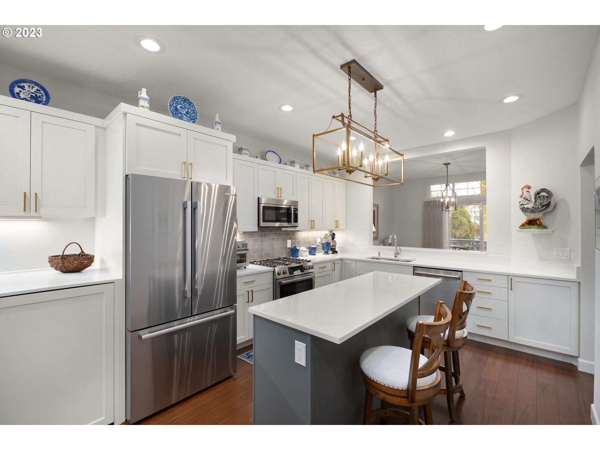 9729 Northwest Silver Ridge Loop Portland, OR 97229 - Photo 10 of 32 a kitchen with refrigerator a sink and chairs