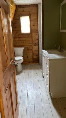 a bathroom with a sink a toilet a window and shower