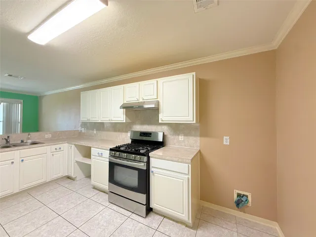 a kitchen with a sink stove and cabinets