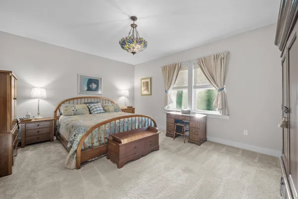 a spacious bedroom with a bed and a chandelier