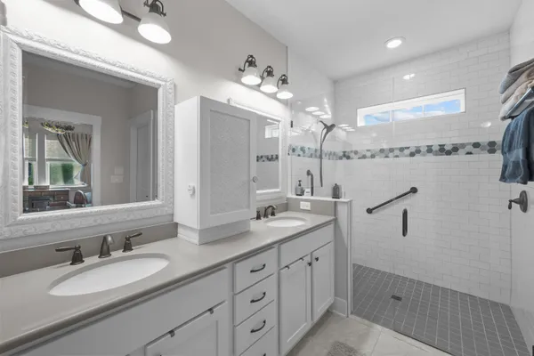 a bathroom with double vanity and a mirror