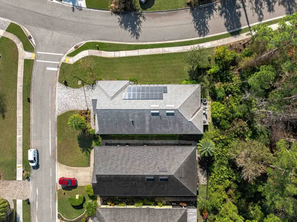 an aerial view of a house with swimming pool garden and mountain view in back
