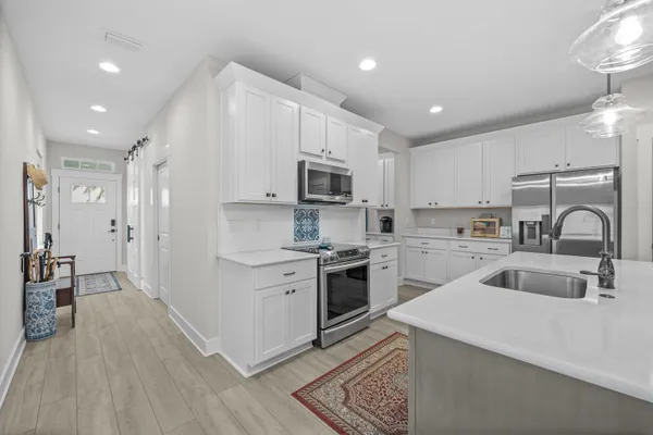 a kitchen with white cabinets and stainless steel appliances