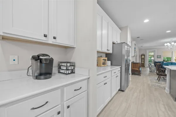 a kitchen with stainless steel appliances granite countertop a refrigerator and white cabinets
