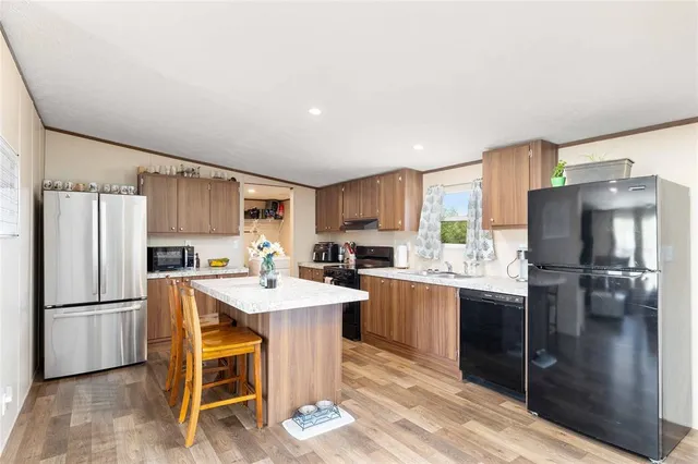 a kitchen with refrigerator cabinets and wooden floor