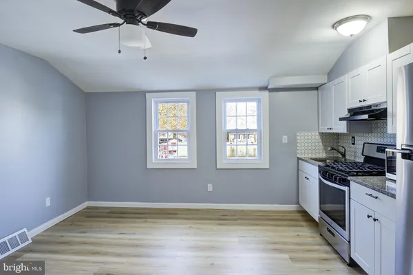 a view of kitchen with stove wooden floor and fan