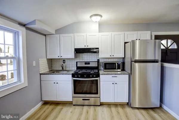 a kitchen with a refrigerator and a stove top oven