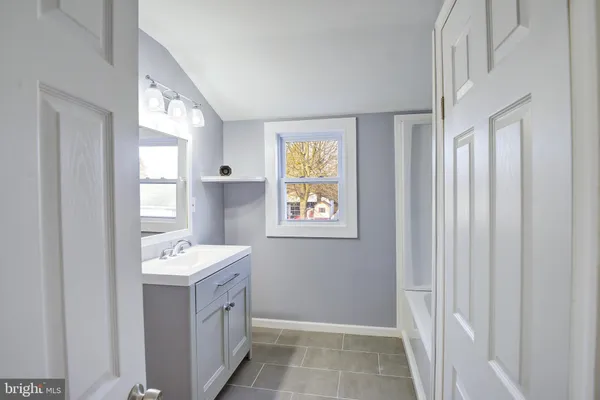 a bathroom with 2 sink mirror and window