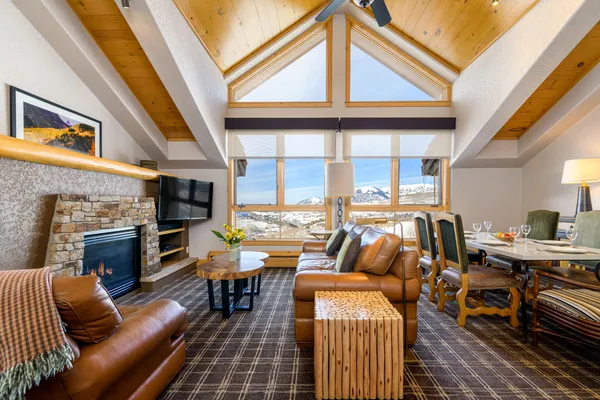a living room with fireplace furniture and a floor to ceiling window