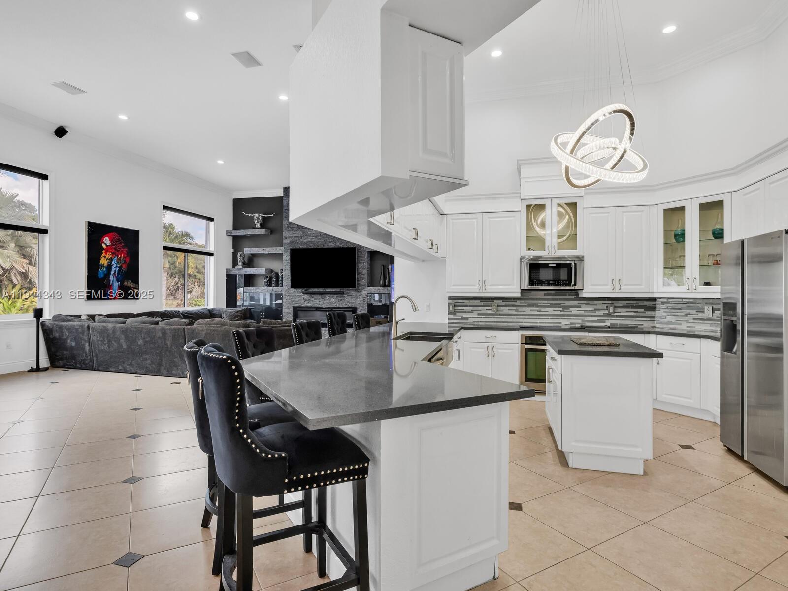 12995 Southwest 40 Street Davie, FL 33330 - Photo 18 of 79 a kitchen with stainless steel appliances granite countertop a stove a sink and a refrigerator