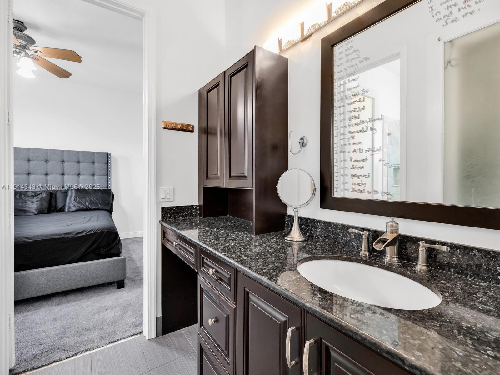 12995 Southwest 40 Street Davie, FL 33330 - Photo 47 of 79 a bathroom with a granite countertop double vanity sink and a mirror