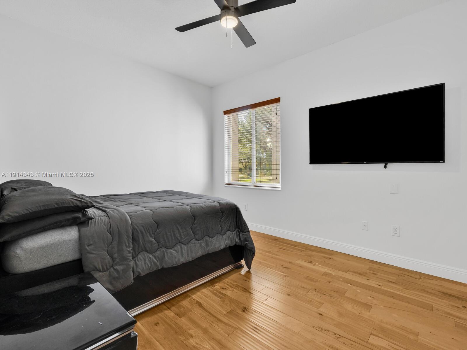 12995 Southwest 40 Street Davie, FL 33330 - Photo 50 of 79 a bedroom with a bed and a flat screen tv