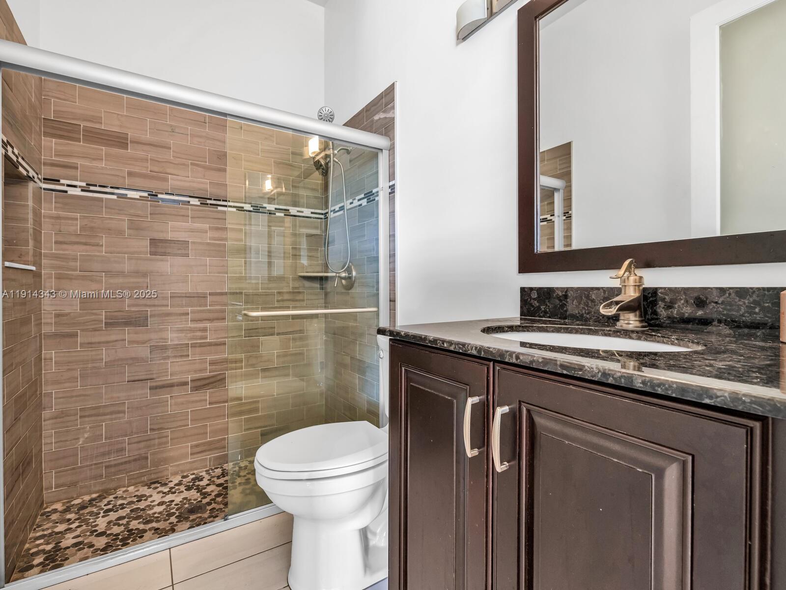 12995 Southwest 40 Street Davie, FL 33330 - Photo 52 of 79 a bathroom with a granite countertop sink toilet and shower