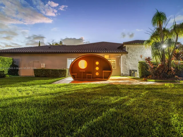 an aerial view of residential houses with outdoor space and lake view in back