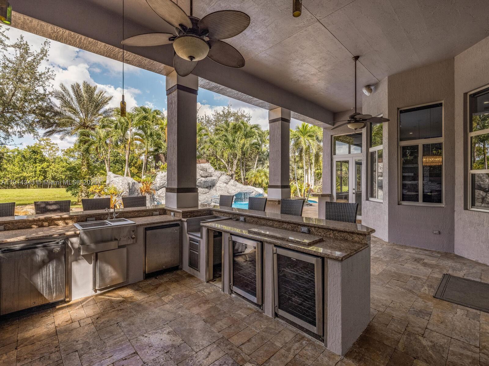 12995 Southwest 40 Street Davie, FL 33330 - Photo 68 of 79 a kitchen with stainless steel appliances granite countertop a stove and a sink