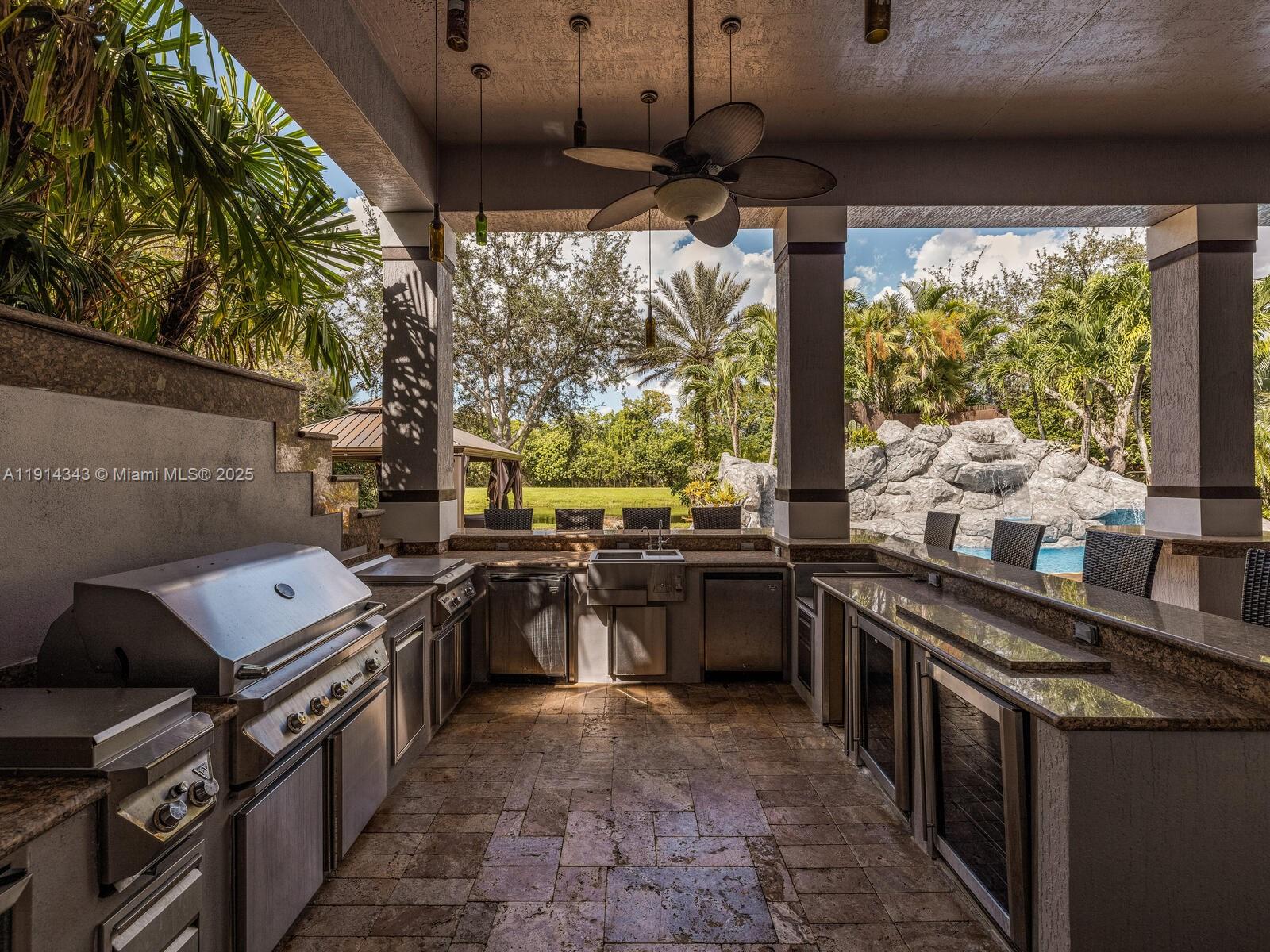 12995 Southwest 40 Street Davie, FL 33330 - Photo 75 of 79 a kitchen with stainless steel appliances granite countertop a stove and a sink