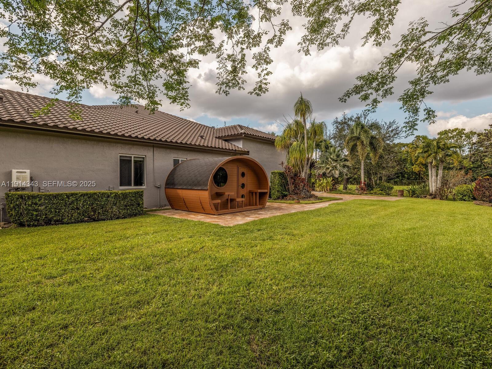 12995 Southwest 40 Street Davie, FL 33330 - Photo 79 of 79 a backyard of a house with lots of green space and fountain