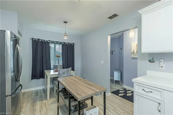 a kitchen with a table chairs refrigerator and cabinets