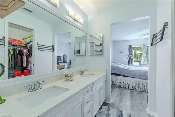 a en suite bathroom with a double vanity sink and a mirror