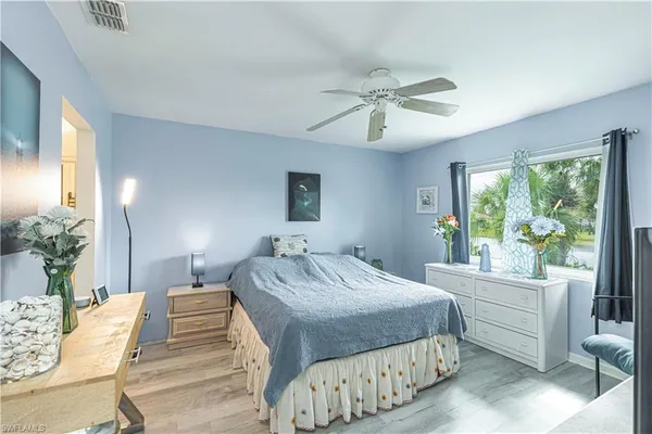 a bedroom with a large bed and a chandelier