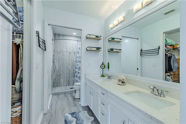 a spacious bathroom with a double vanity sink a large mirror a shower and a bathtub