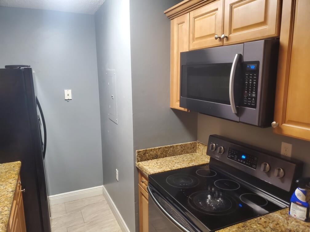 1068 Benoist Farms Road, Unit 204 West Palm Beach, FL 33411 - Photo 5 of 11 a kitchen with a stove and a microwave