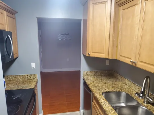 a kitchen with granite countertop a sink and a stove