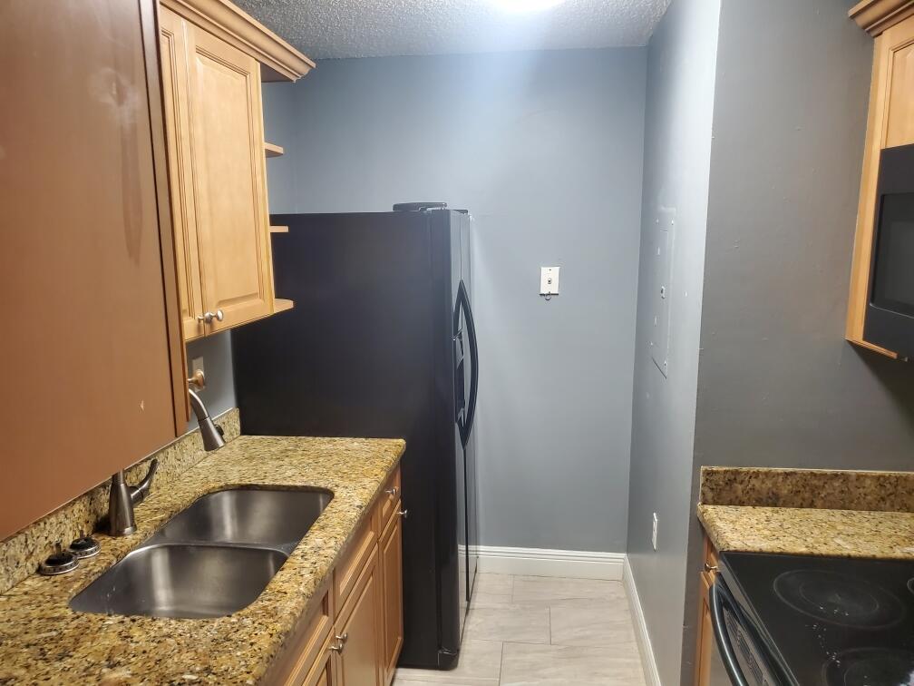 1068 Benoist Farms Road, Unit 204 West Palm Beach, FL 33411 - Photo 8 of 11 a bathroom with a sink and a mirror