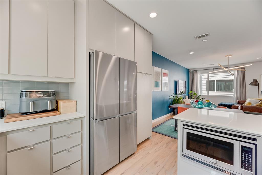 4705 Bryan Street, Unit 302 Dallas, TX 75204 - Photo 15 of 28 a kitchen with stainless steel appliances a refrigerator sink and cabinets