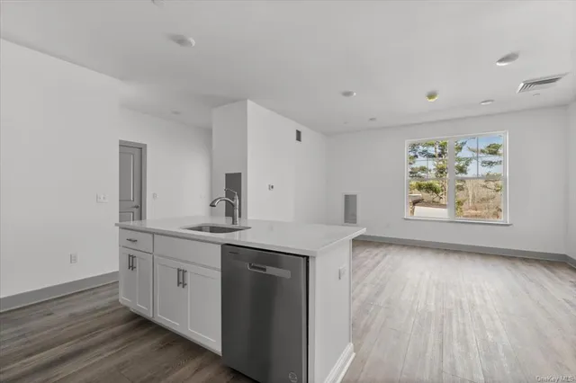 a view with cabinets a sink and wooden floor