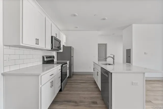 a kitchen with white cabinets sink and stove