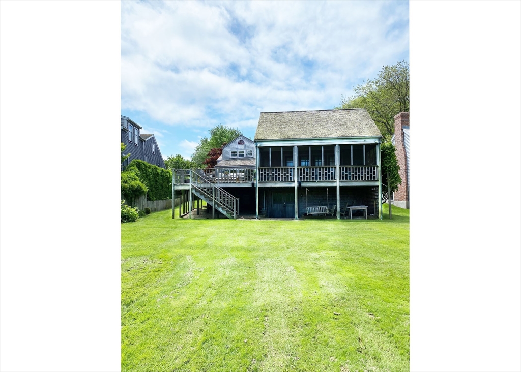 7 North Liberty Street Nantucket, MA 02554 - Photo 2 of 28 a view of a backyard with table and chairs and potted plants