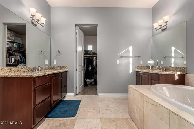 a bathroom with a granite countertop double vanity sink a mirror and shower