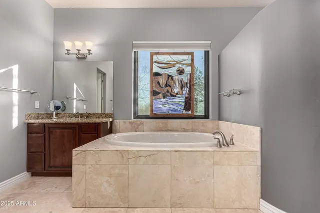 a bathroom with a tub a sink and mirror