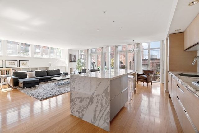 a living room with furniture large windows and wooden floor