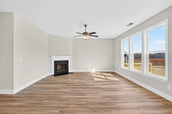 a view of an empty room with a window and a fireplace